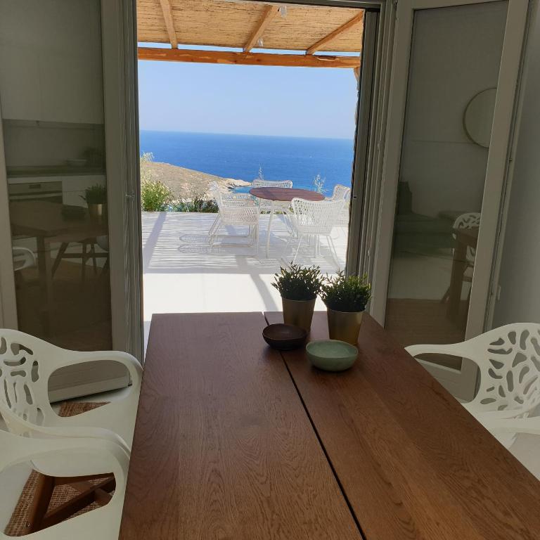 a dining room table with a view of the ocean at Blue Sea Villa in Serifos Chora