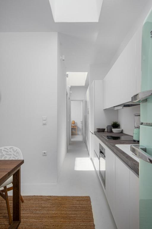 a kitchen with white walls and a long hallway at Blue Sea Villa in Serifos Chora