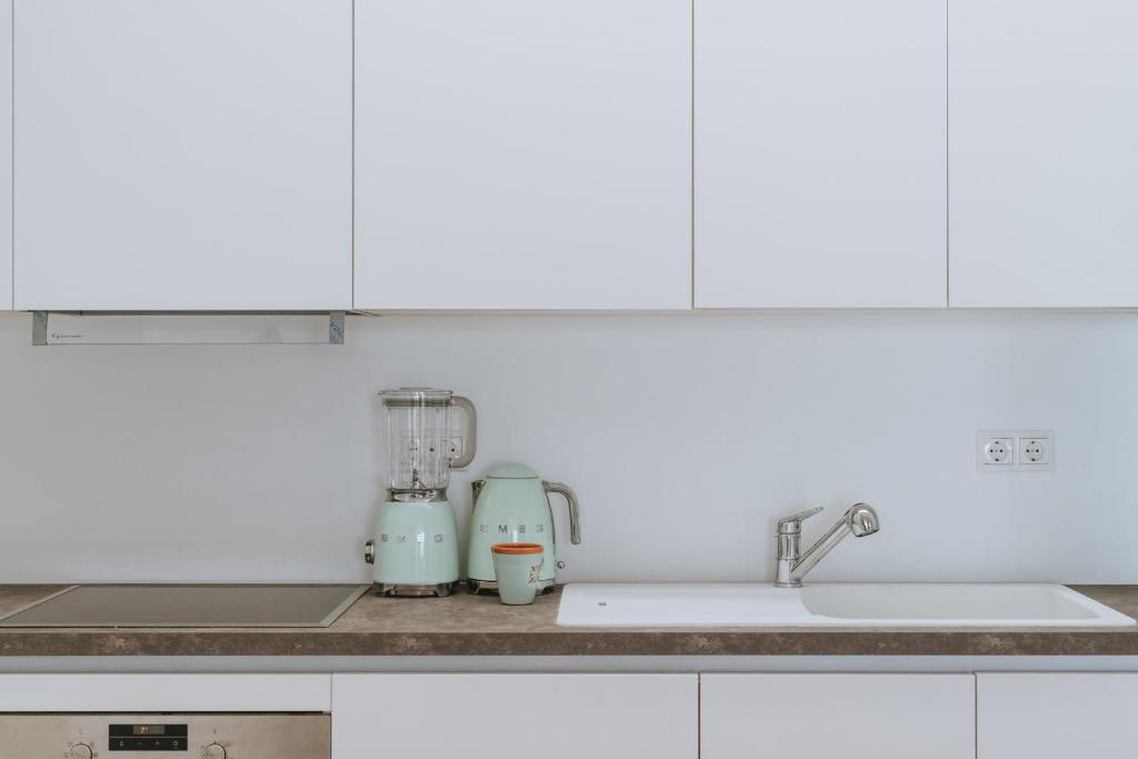 a kitchen counter with a mixer and a sink at Blue Sea Villa in Serifos Chora
