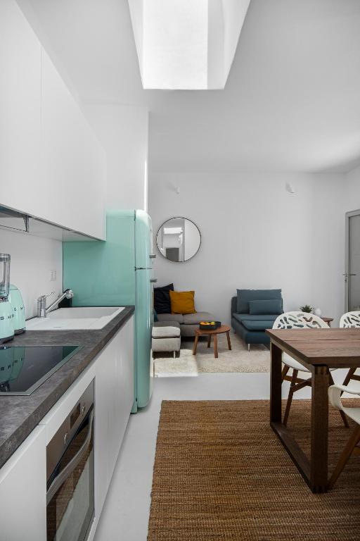 a kitchen with a blue refrigerator and a living room at Blue Sea Villa in Serifos Chora