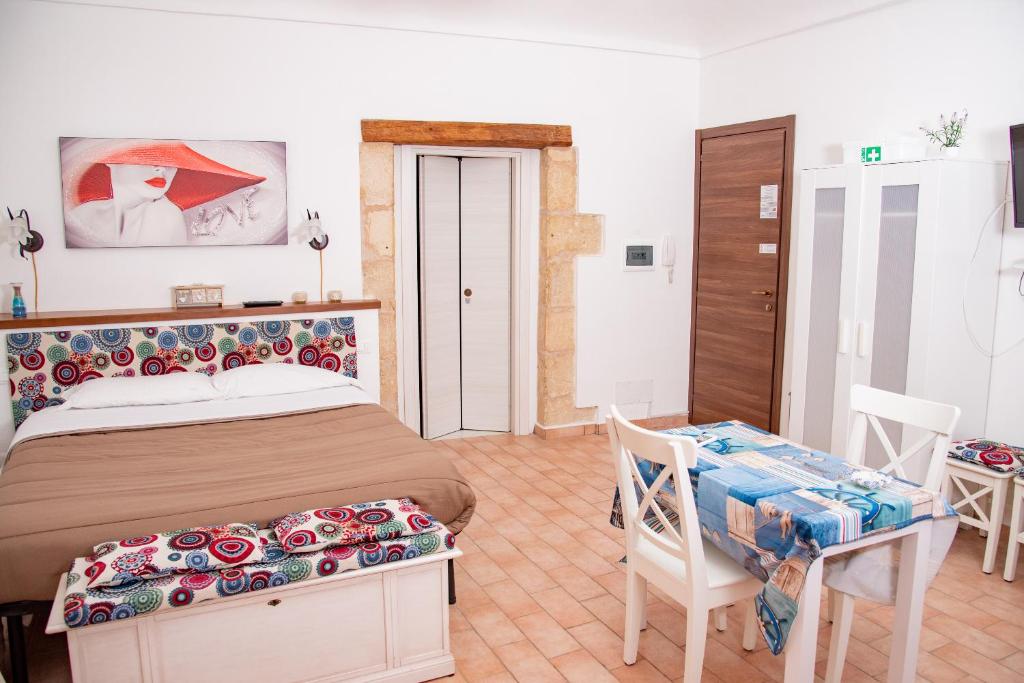 sypialnia z łóżkiem, stołem i krzesłami w obiekcie Xenia - Il Vicoletto delle Dee w Syrakuzach