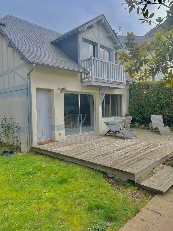 une terrasse en bois devant une maison dans l'établissement Maison proche plages., à Benerville-sur-Mer