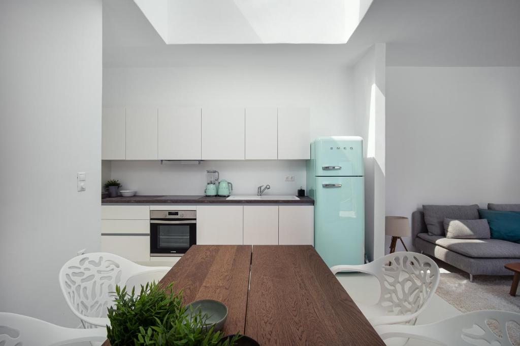 a kitchen with a wooden table and a blue refrigerator at Blue Sea Villa in Serifos Chora