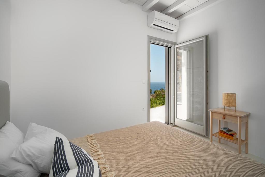 a bedroom with a bed with a view of the ocean at Blue Sea Villa in Serifos Chora