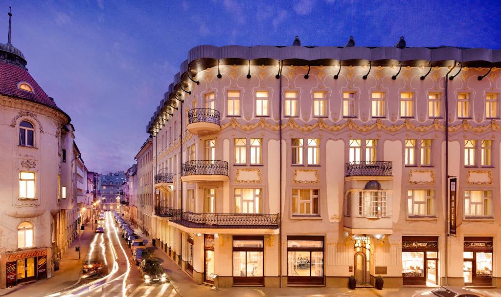 een groot wit gebouw met verlichting in een stadsstraat bij Roset Hotel & Residence in Bratislava