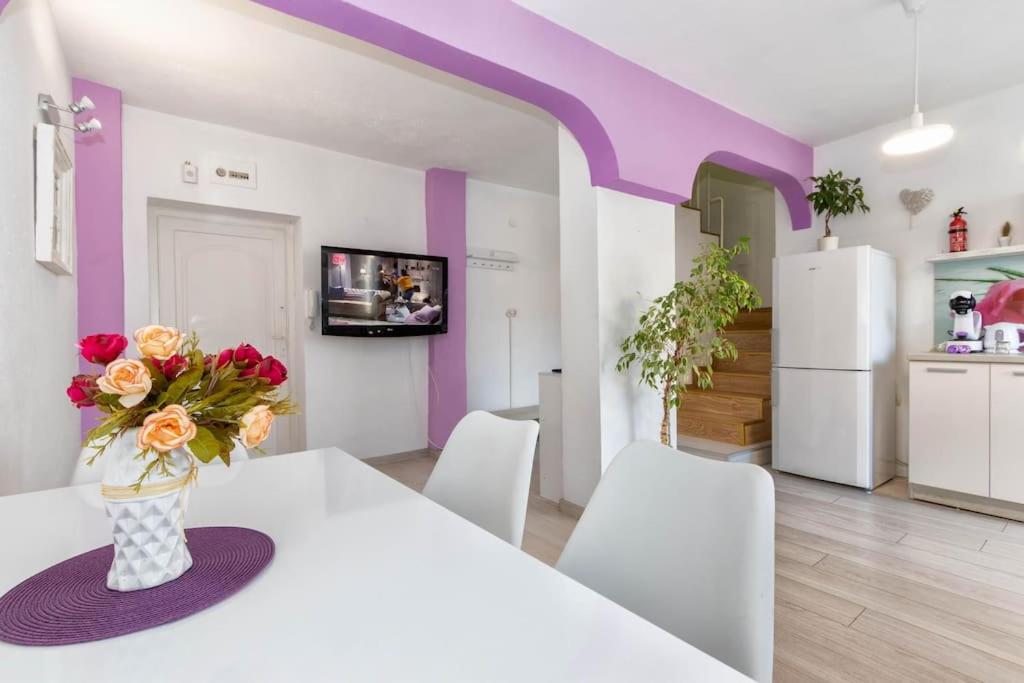 een keuken met een witte tafel en een vaas met bloemen bij Sunny 2-Bedroom Maisonette Varna & Parking in Varna