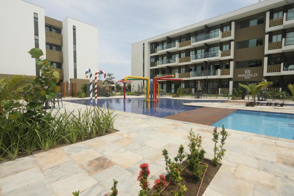 einen Pool mit Spielplatz vor einem Gebäude in der Unterkunft Muro Alto Mana Beach Experience Apartamento B104 in Ipojuca
