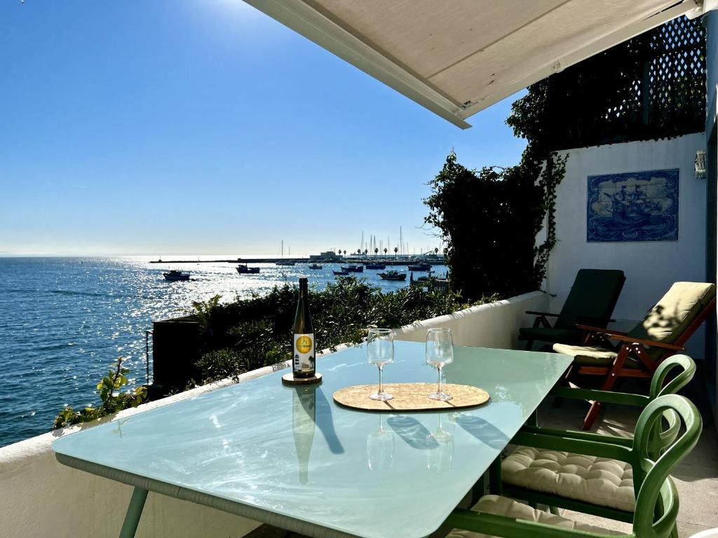 uma mesa com uma garrafa de vinho e dois copos em Ocean dream apartment em Cascais