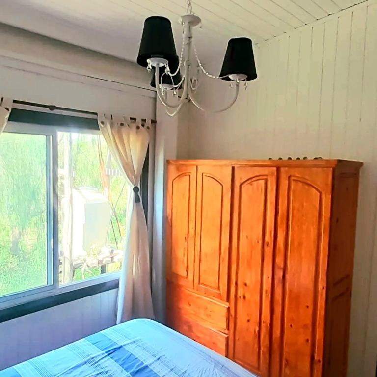1 dormitorio con cama, ventana y lámpara de araña en Arco iris en Tigre