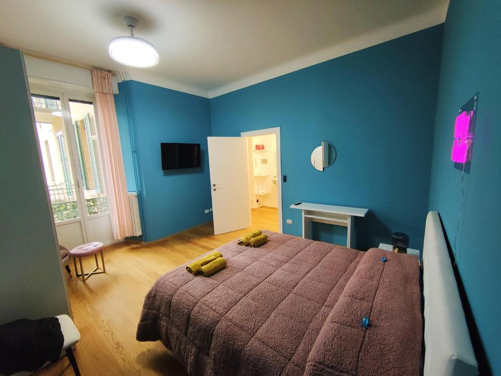 1 dormitorio azul con 1 cama con 2 almohadas amarillas en Amio Apartment - next to M5 Ca Granda, en Milán