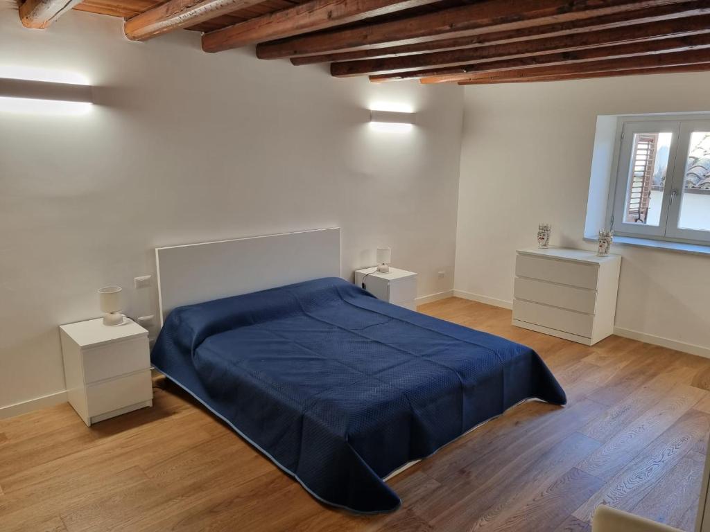 1 Schlafzimmer mit einem blauen Bett und 2 Tischen in der Unterkunft Casa Azzurra - Palazzo del Buonpastore in Palermo