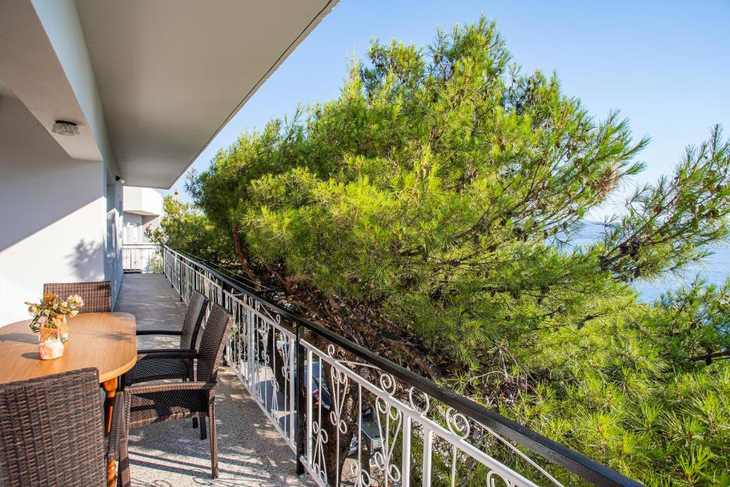 a balcony with a table and chairs and trees at Apartments Adisa in Omiš