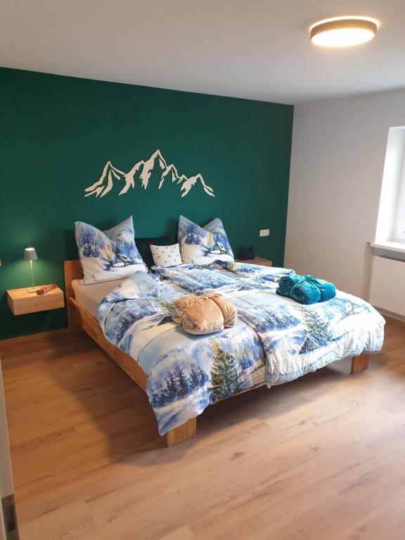 ein Schlafzimmer mit einem Bett mit einer grünen Wand in der Unterkunft Panoramablick in Breitenwang