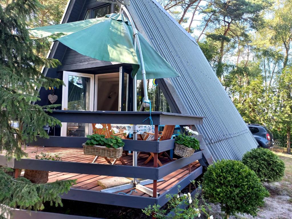 ein winziges Haus mit einer Veranda und einem blauen Dach in der Unterkunft Domek letniskowy Pirat in Mrzeżyno