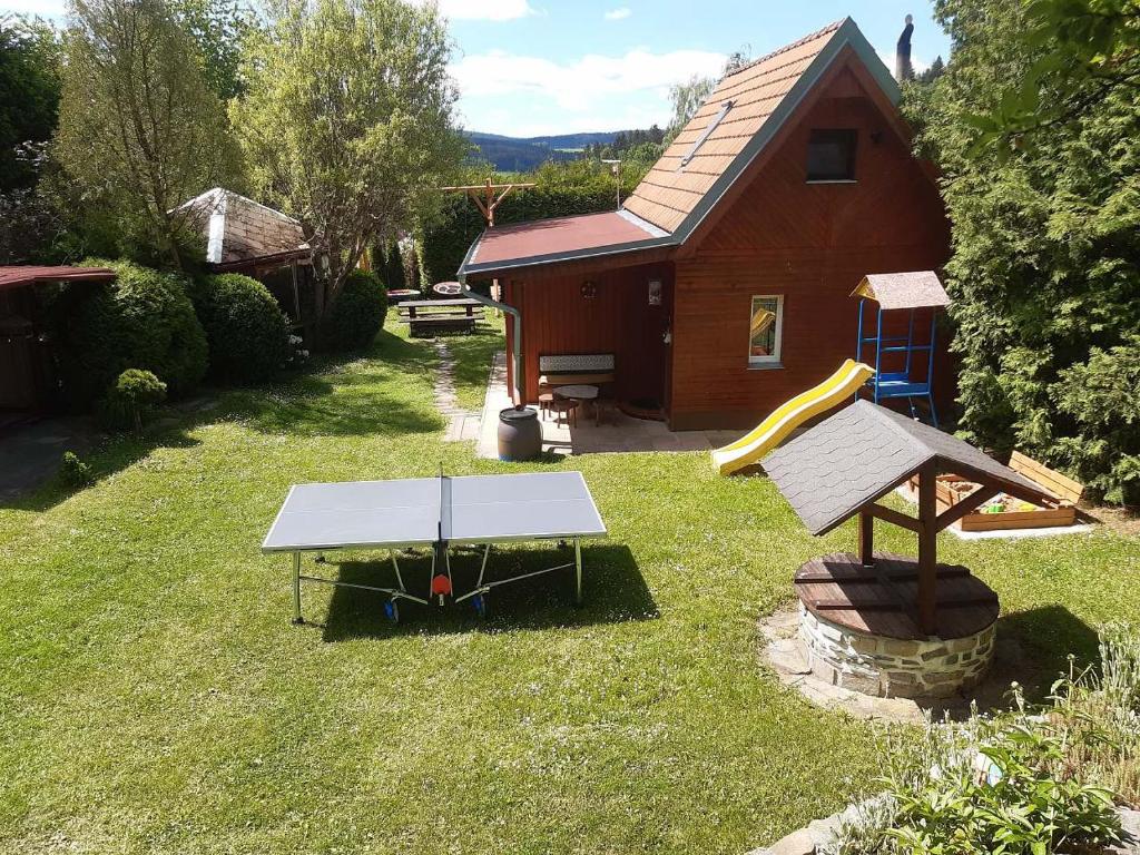 a backyard with a play table and a house at Chata u Kapličky - Veleslavice in Větřní
