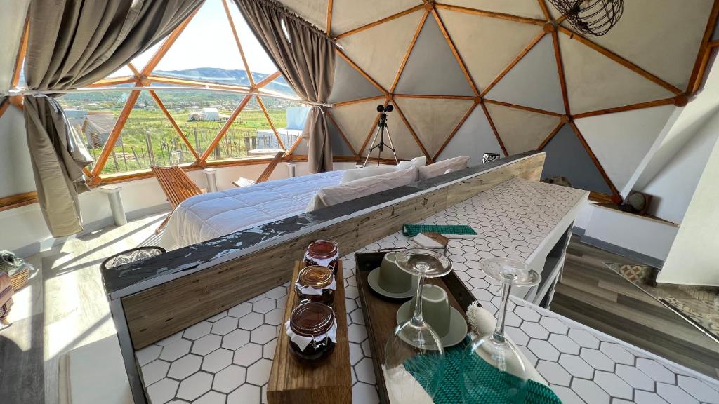 Zimmer mit einem Bett in einer Jurte mit einem Tisch in der Unterkunft Santerra, Valle de Guadalupe in Valle de Guadalupe