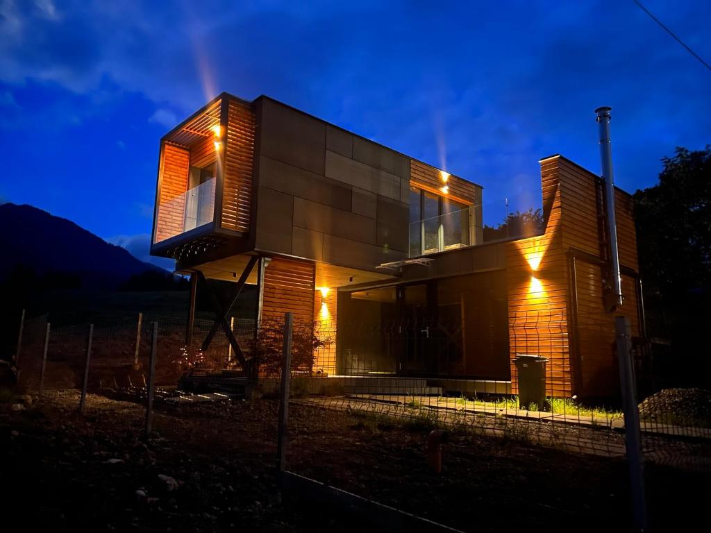 una casa que se ilumina por la noche en The kube by the mountain en Timisul de Jos