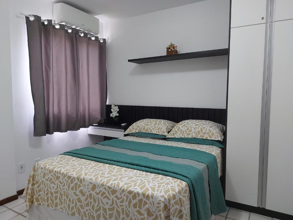 - une chambre dotée d'un lit avec une couverture verte et blanche dans l'établissement Apartamento na praia de Jatiuca, à Maceió
