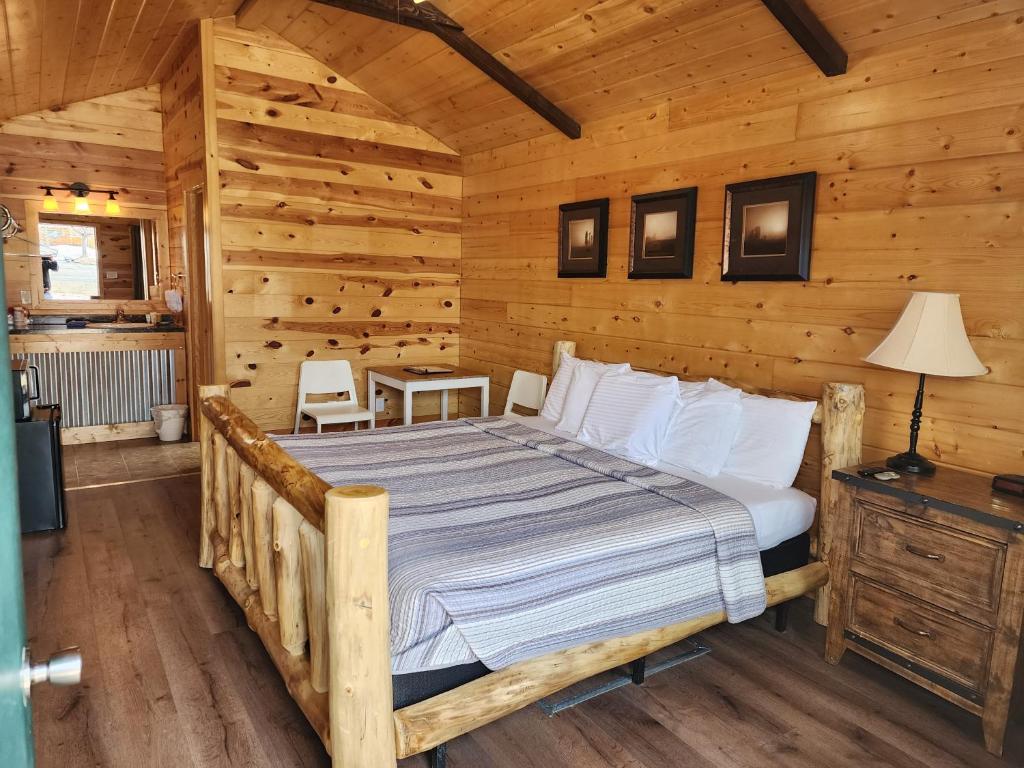 1 dormitorio con 1 cama en una cabaña de madera en Bryce Valley Lodging en Tropic