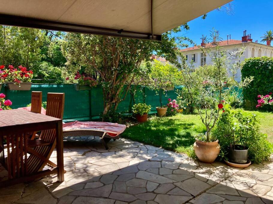 a patio with a table and chairs in a yard at Provencal house, sea side, private parking in Nice