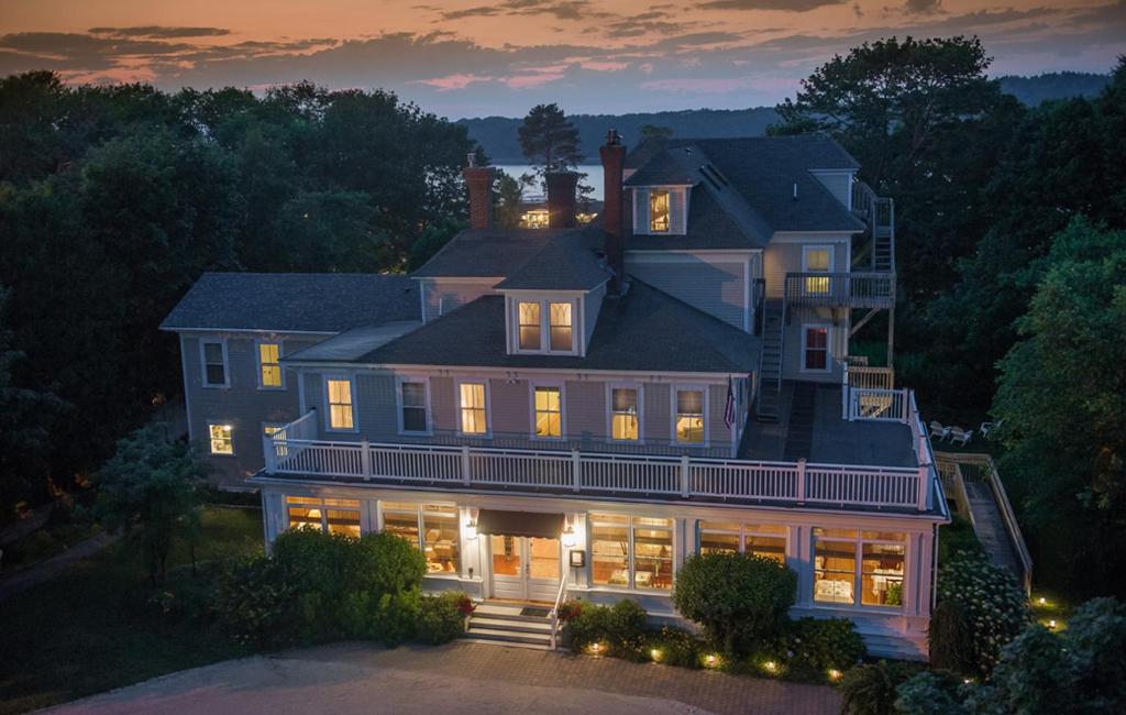 una grande casa con le luci accese di notte di Bass Cottage & Ullikana a Bar Harbor