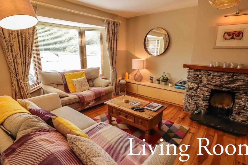 a living room with a couch and a fireplace at Skelligway Kenmare - Your Luxury Holiday Home in Kenmare