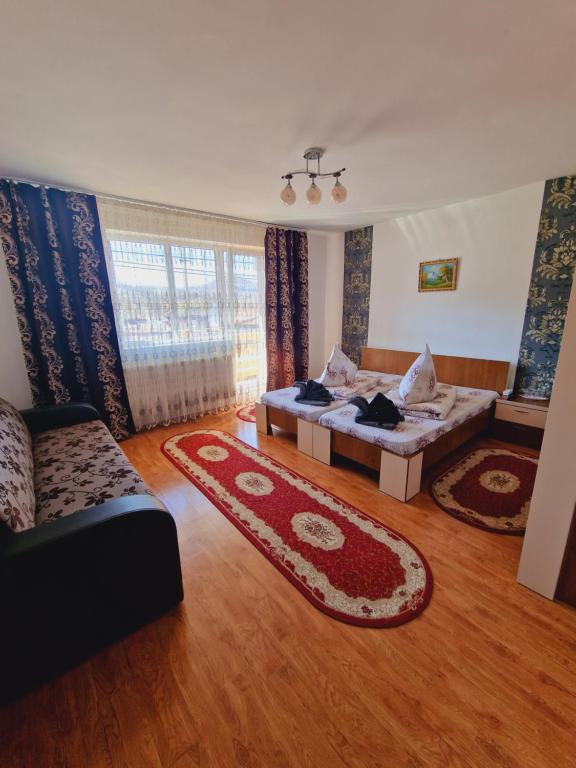 - un salon avec un lit et un canapé dans l'établissement Pensiunea Adriana, à Vadu Izei