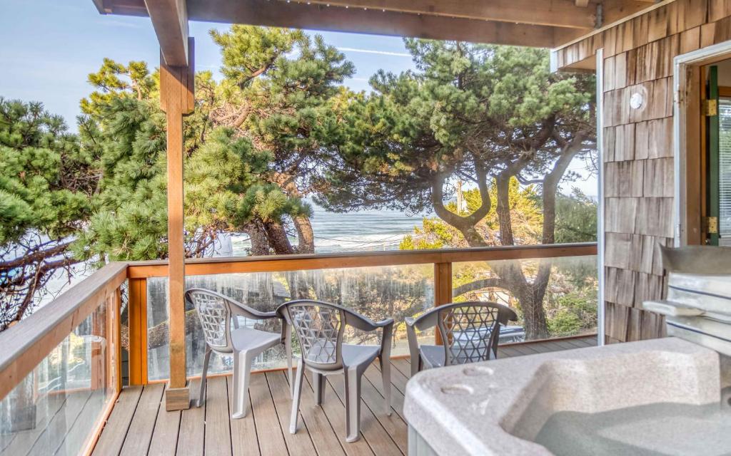 a balcony with a tub and chairs and a view of the ocean at Sands of Time in Lincoln City