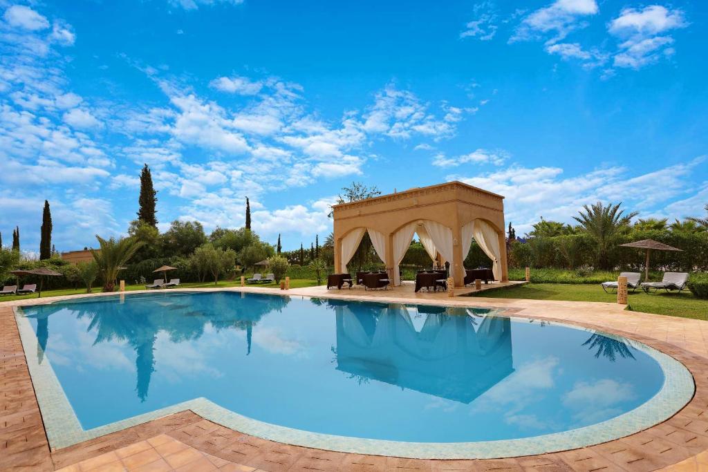 a large swimming pool with a gazebo at Atlas Widan in Marrakesh