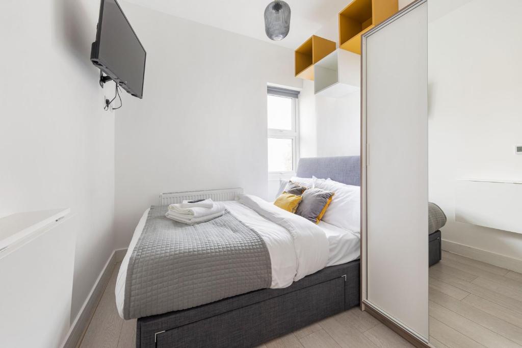a small bedroom with a bed and a mirror at Functional Budget Stay with Wi-Fi and Laundry Facilities near Tube Station in London