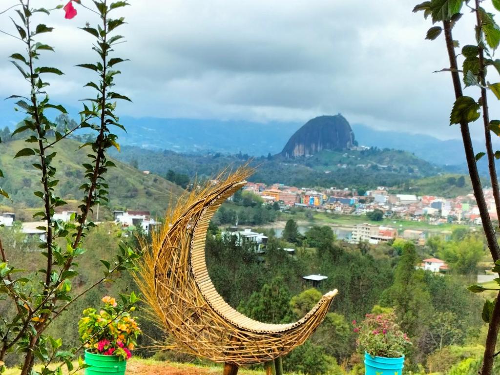 a rattan hammock with a view of a mountain at El Mirador de Guatape APTO in Guatapé