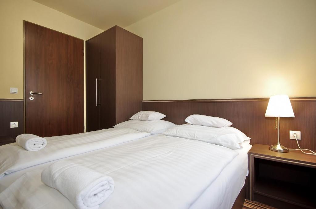 Łóżko lub łóżka w pokoju w obiekcie Corvin Apartman