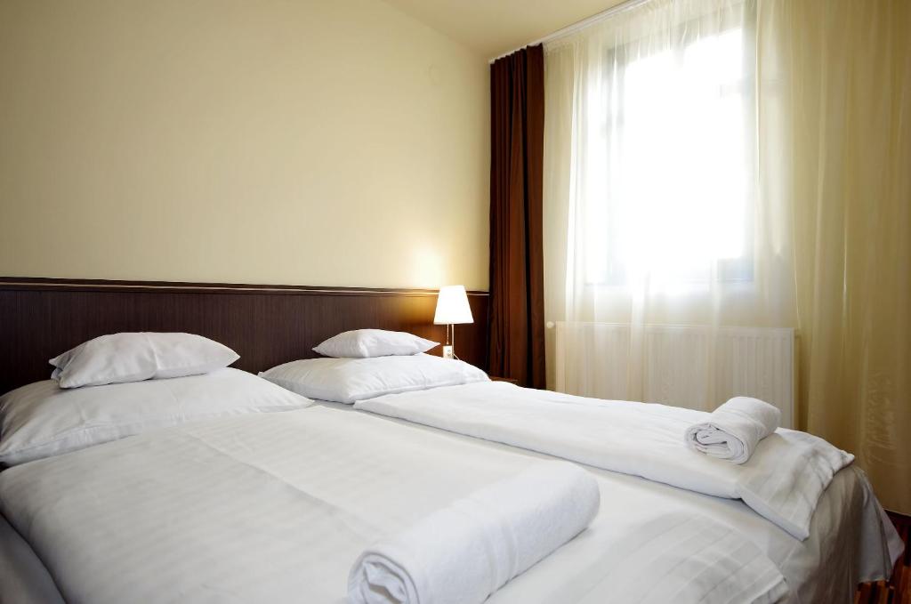 Łóżko lub łóżka w pokoju w obiekcie Corvin Apartman