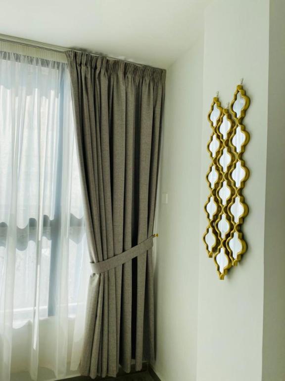 a window with a curtain and a mirror on the wall at Arabesque Hotel in Amman