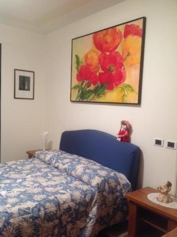 Un dormitorio con una cama azul y una pintura en la pared en B&B la casa di Pina, en Bérgamo