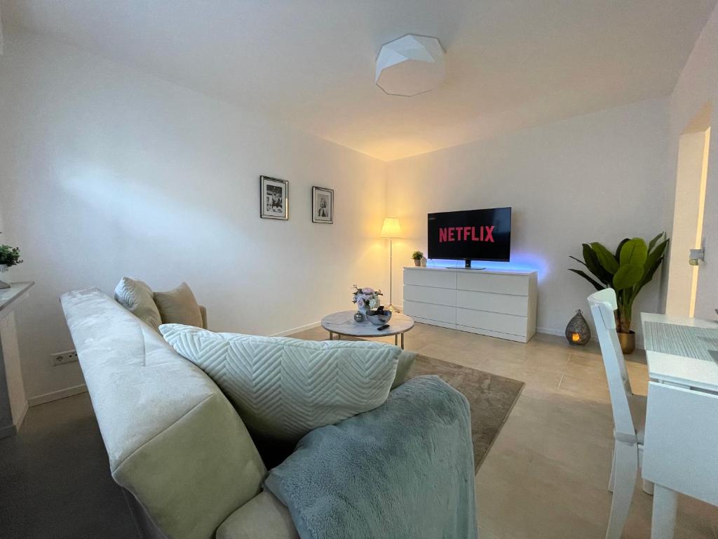 uma sala de estar com um sofá e uma televisão em Stilvolle 52qm Wohnung in attraktiver Lage em Essen