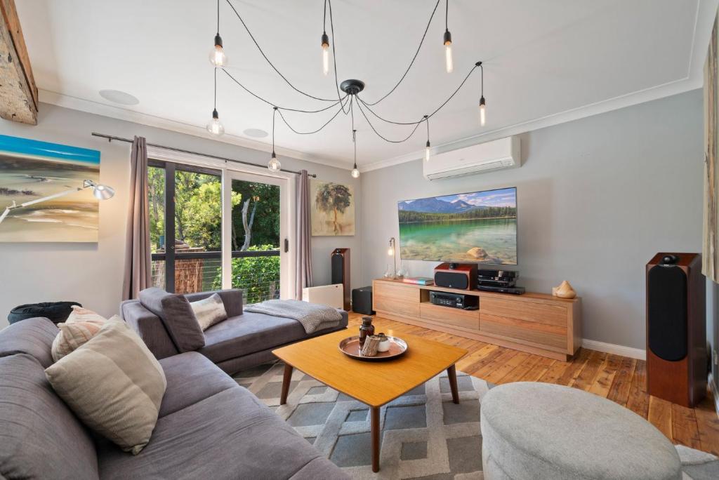 Delamarele في Medlow Bath: غرفة معيشة بها أريكة وطاولة