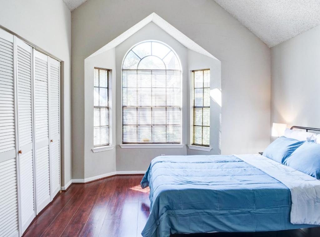 a bedroom with a bed and a large window at Lovely 2 bedroom, 1 bath condo with pools and gym. in Houston