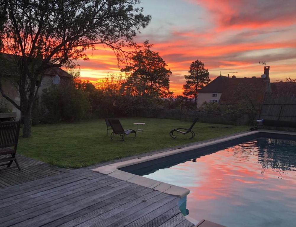 een zonsondergang boven een achtertuin met een zwembad bij Casa Bella in Charroux-dʼAllier