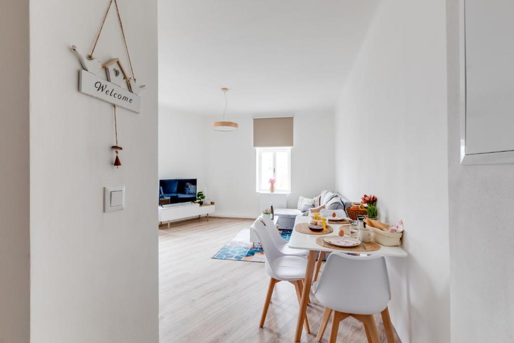 a white living room with a table and chairs at Modern, bright and spacious apartment in Prague