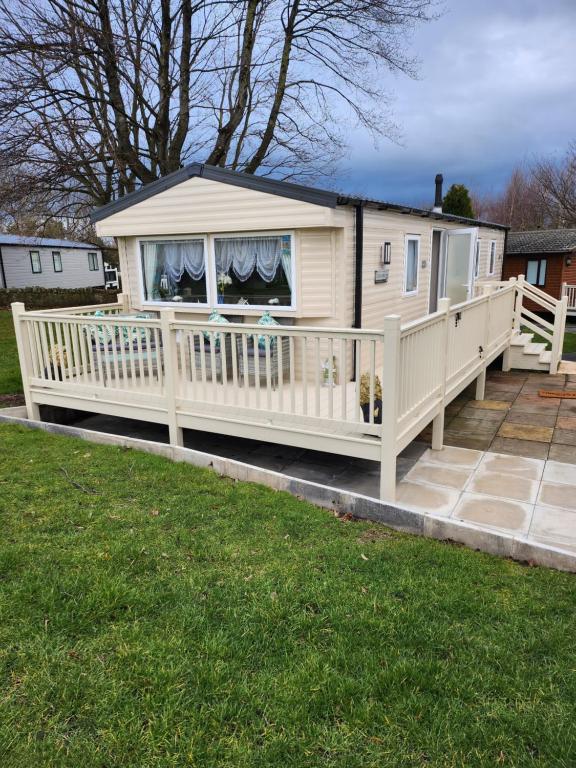 a mobile home with a porch and a deck at Rosie's Seton Retreat in Port Seton