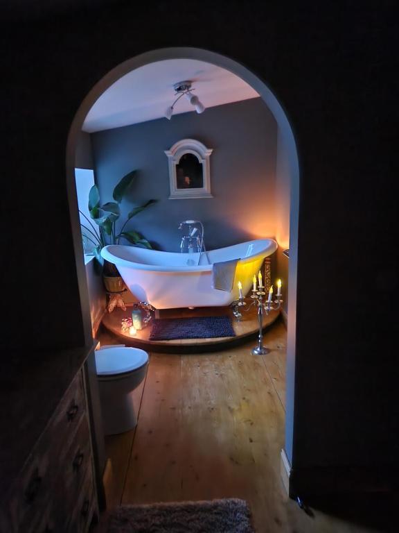 科爾朵的住宿－Fyne Byre Cottage - Barn Conversion with Hot Tub，拱门上带浴缸的浴室