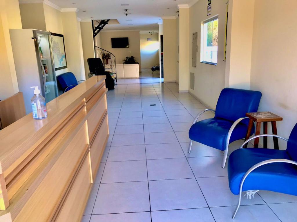 een wachtkamer in een ziekenhuis met blauwe stoelen bij Santa Catarina Hotel in Aparecida