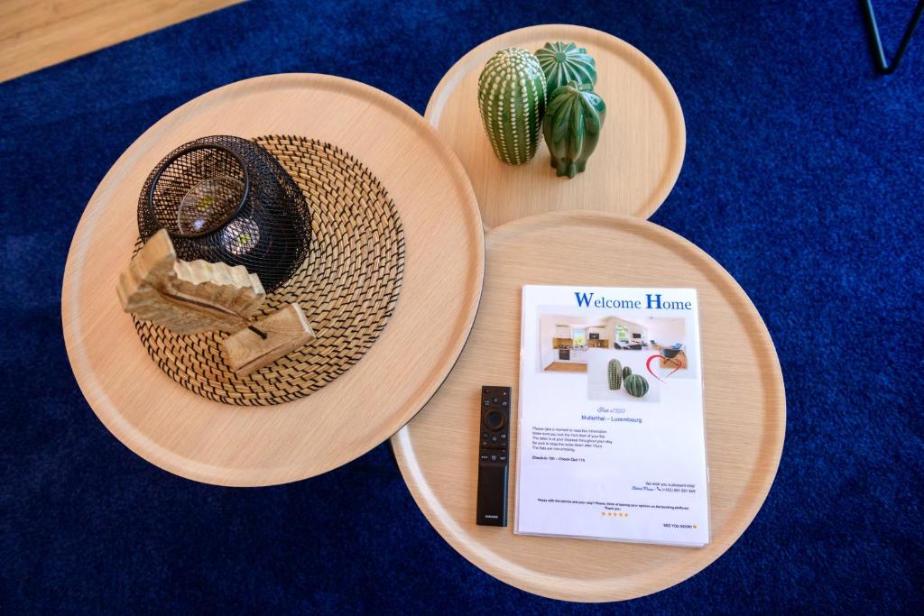 two wooden plates with a wicker hat and a book at Appart-Hotel Ernz Noire in Grundhof