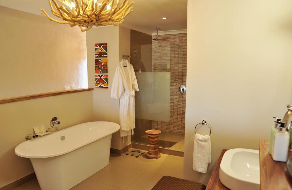a bathroom with a bath tub and a sink at Victoria Falls Safari Club in Victoria Falls