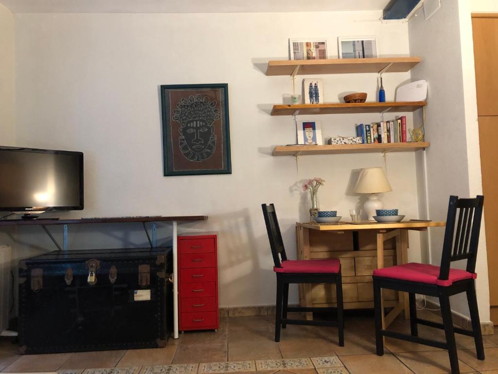 Habitación con 2 sillas, escritorio y TV. en Estudio Casco antiguo Tarragona, en Tarragona