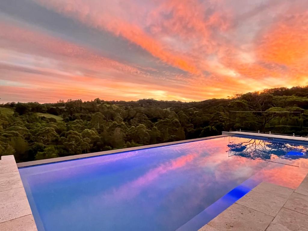 a swimming pool with a sunset in the background at Mapleton Springs in Mapleton