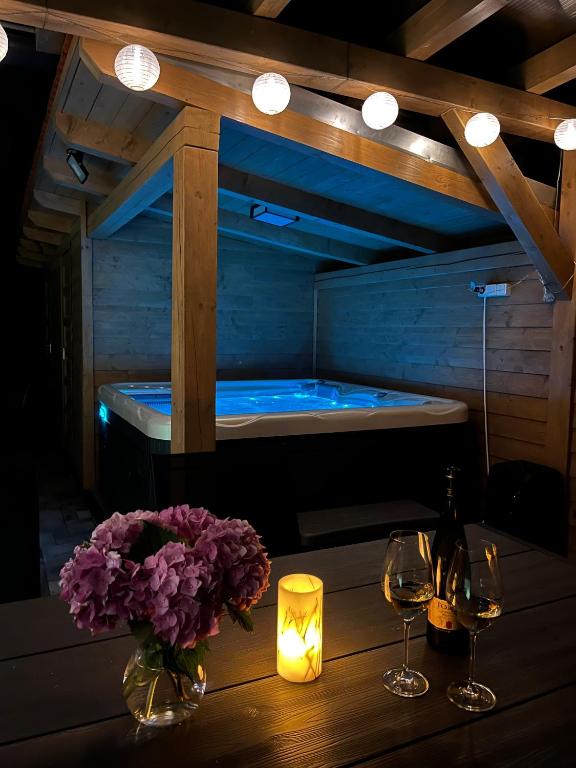 a table with two glasses of wine and a tub at Tópart Nyaraló in Sárospatak