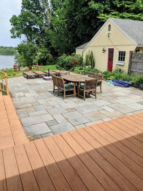 a patio with a table and chairs on a wooden deck at Waterfront Getaway in Wethersfield