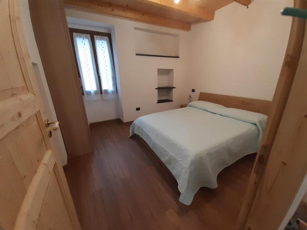 1 dormitorio con cama blanca y ventana en Casa Ylenia en Borzonasca